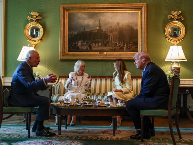Charles III, Camilla, Melania et Donald Trump assis dans un salon autour d'une table où sont posés du miel, du thé et des pâtisseries.