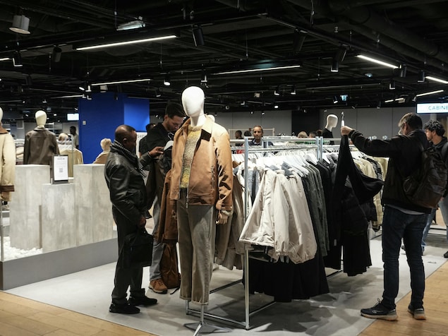 Des clients regardent des vêtements pour hommes.