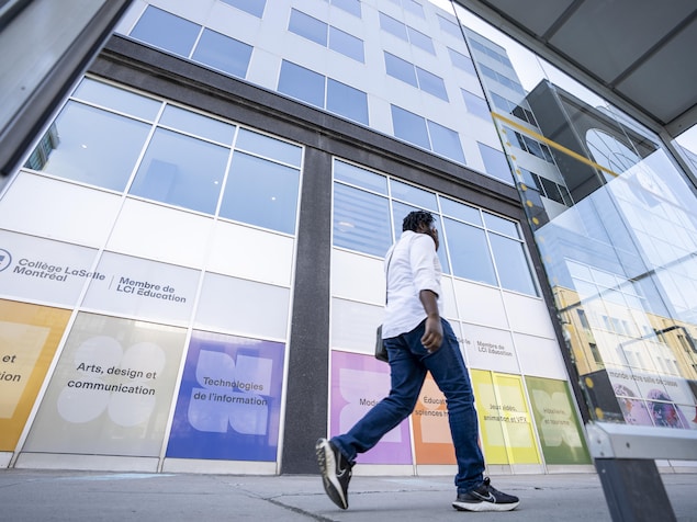 Un homme marche devant l'établissement scolaire.