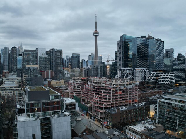 Images aériennes (par drone) de la construction de condominiums, de la Tour CN et de la ligne d'horizon en soirée à Toronto.