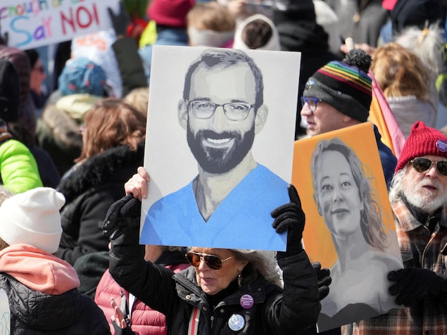 Des manifestants brandissent des pancartes représentant Renee Good et Alex Pretti.
