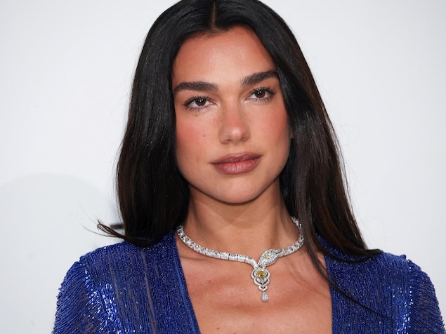 Dua Lipa pose pour la caméra en habit de soirée.
