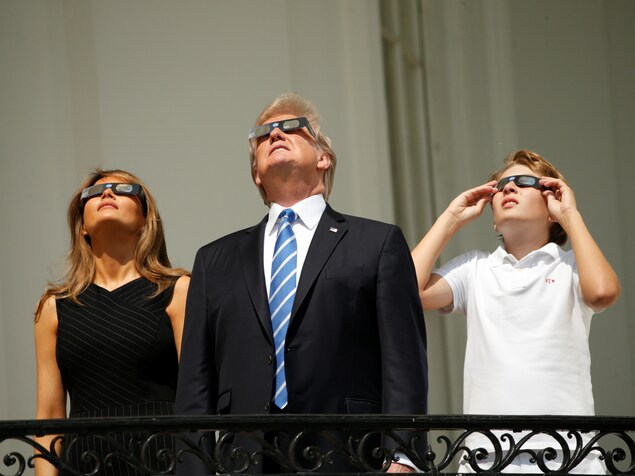 Le président Donald Trump observe l'éclipse solaire en compagnie de sa femme, Melania, et de son fils, Barron. Le président Donald Trump observe l'éclipse solaire en compagnie de sa femme, Melania, et de son fils, Barron.