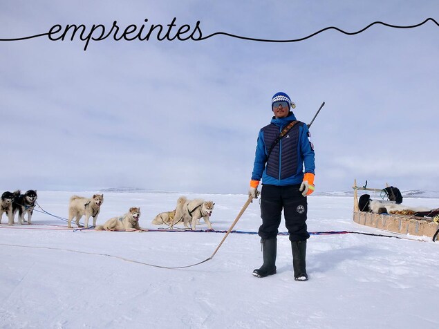 Devon Manik est debout sur la banquise, un fouet à la main devant son traîneau avec ses chiens, au mois de juin près de Resolute Bay, dans le nord du Nunavut.