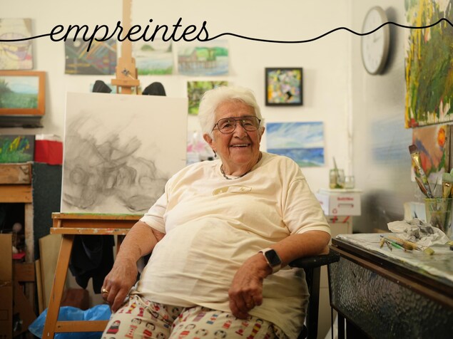 Lucille Proulx est assise dans son atelier, devant son chevalet avec une œuvre en cours, en juin 2023, à Victoria, en Colombie-Britannique.