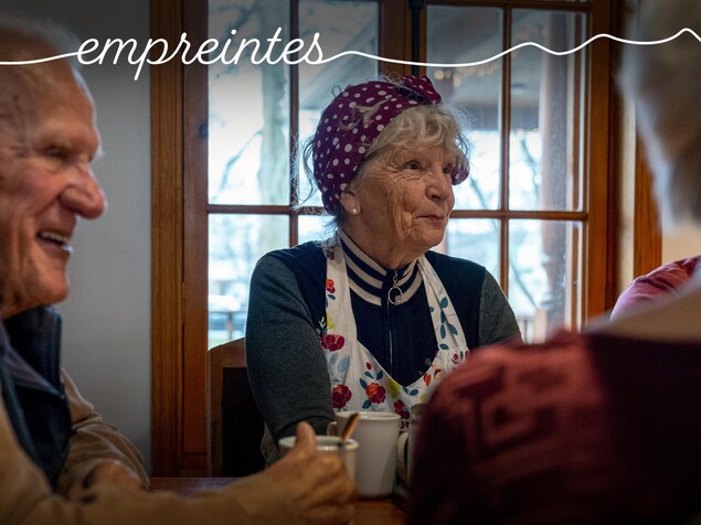 Un groupe d'aînés, en pleine discussion, assis d'autour d'une table. 