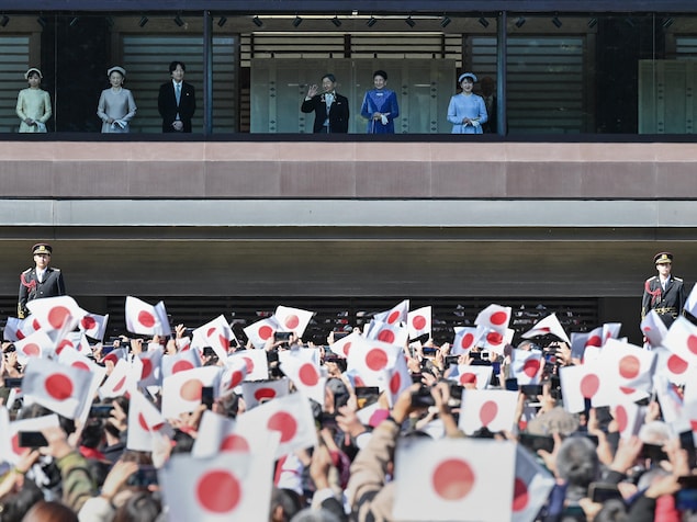 Des sympathisants agitent des drapeaux nationaux alors que l'empereur Naruhito du Japon (3e à droite en haut) fait son apparition aux côtés de l'impératrice Masako (2e à droite), de leur fille la princesse Aiko (à droite), du prince héritier Akishino (3e à gauche), la princesse héritière Kiko (2e à gauche) et leur fille, la princesse Kako (à gauche), sur le balcon du Palais impérial à l'occasion du 65e anniversaire de l'empereur, à Tokyo, le 23 février 2025.