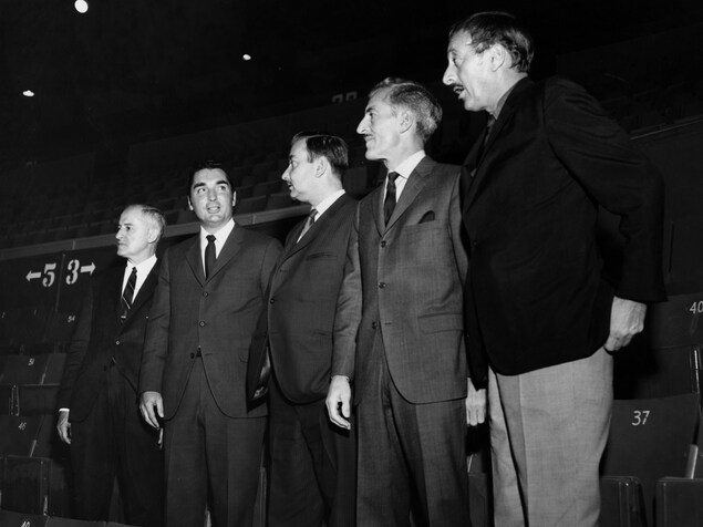 Dans les gradins du Forom, Paul-Marcel Raymond, Lionel Duval, Guy Desormeaux, René Lecavalier et Jean-Maurice Bailly sont debout côte à côte Dans les gradins du Forom, Paul-Marcel Raymond, Lionel Duval, Guy Desormeaux, René Lecavalier et Jean-Maurice Bailly sont debout côte à côte