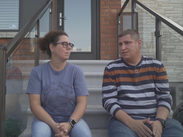 Le couple est assis devant sa maison, dans les escaliers. Le couple est assis devant sa maison, dans les escaliers.