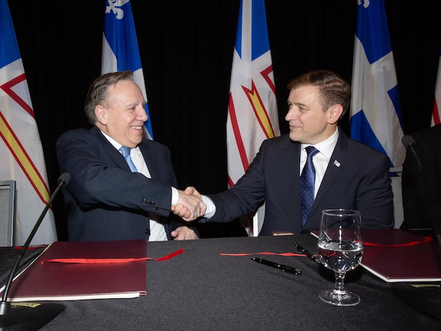 MM. Legault et Furey se serrent la main.