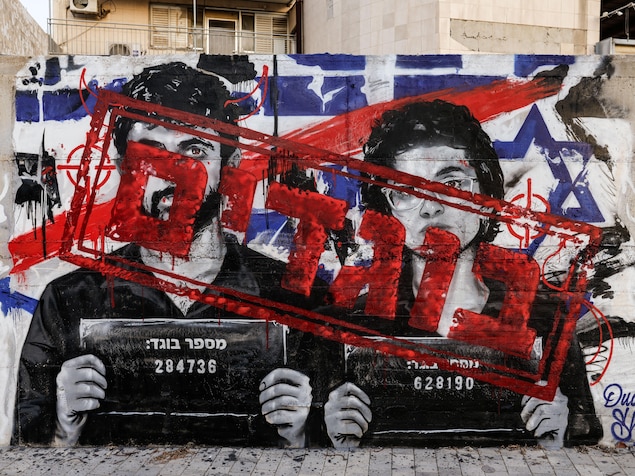 Un graffiti représentant Yuval Abraham et Rachel Szor, les réalisateurs du documentaire Naza, ainsi que le mot « traîtres » en hébreu, sur un mur.
