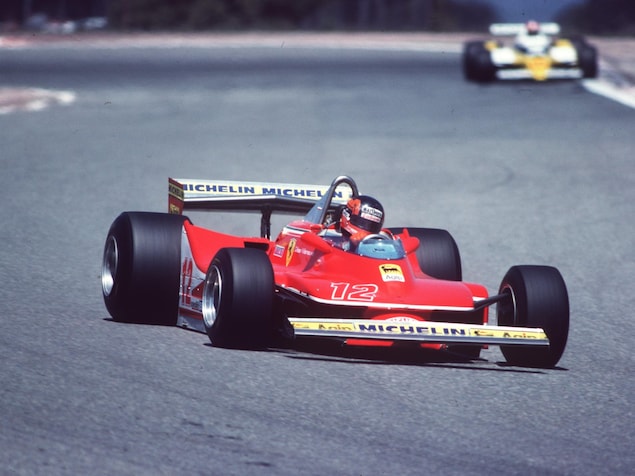 Une voiture formule 1 rouge entre dans un virage.