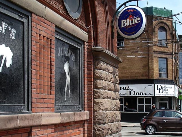 La façade du bar Jilly's, avec des silhouettes de femmes faisant de la danse poteau.