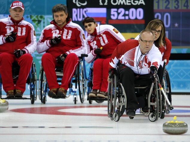 Un homme en fauteuil roulant lance une pierre. Un homme en fauteuil roulant lance une pierre.