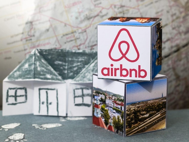 Le logo de Airbnb figure sur un cube dont les autres faces sont couvertes d'une photo de paysage.