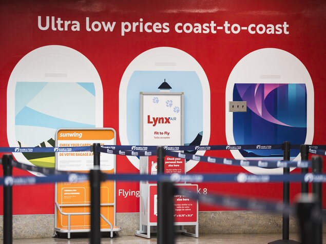 Des affiches aux couleurs de Lynx Air dans un aéroport.