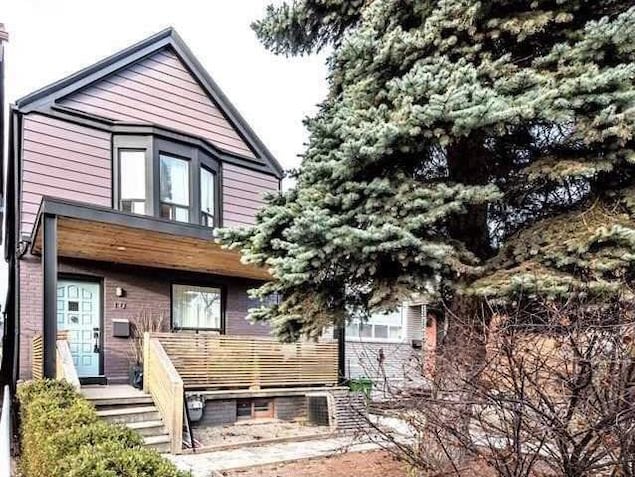 Un sapin cache un cottage en brique et en déclin à Toronto. Un sapin cache un cottage en brique et en déclin à Toronto.