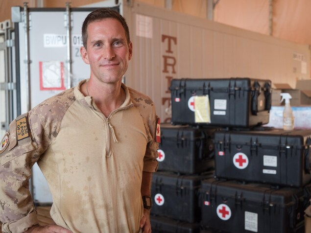 Andrew McLaren, devant une pile de boîtes d'équipement médical. Andrew McLaren, devant une pile de boîtes d'équipement médical.