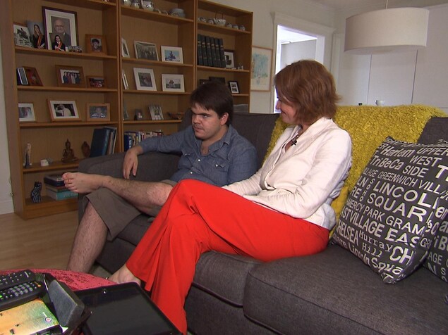 La mère et son fils sont assis sur le divan. La mère et son fils sont assis sur le divan.