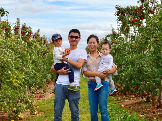 Meng Zhao, Frank Zhang et leurs enfants dans un verger. Meng Zhao, Frank Zhang et leurs enfants dans un verger.