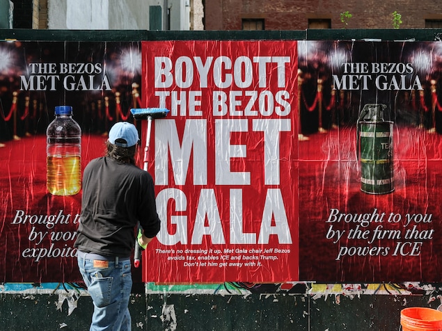 Une personne appose des affiches « Boycottons le Met Gala de Bezos » à New York, le 15 avril 2026. 