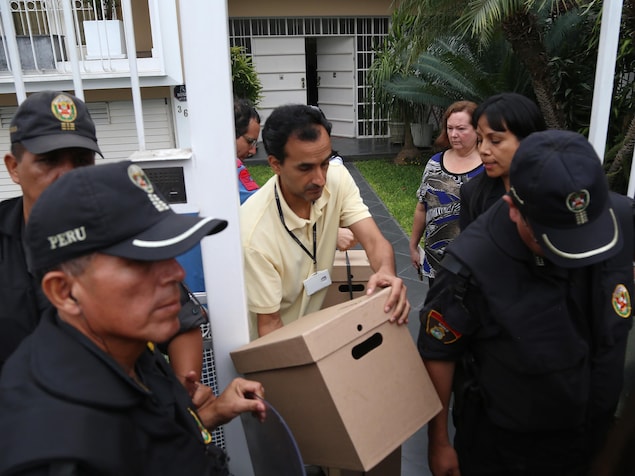 Un homme, entouré de policiers, sort une boîte de documents des bureaux de Mossack Fonseca Un homme, entouré de policiers, sort une boîte de documents des bureaux de Mossack Fonseca