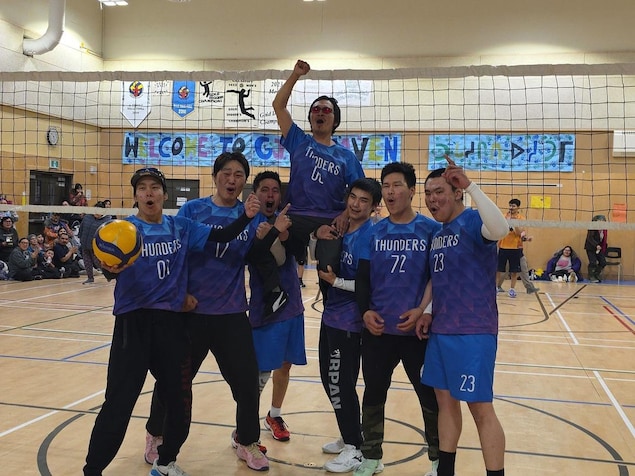 Une équipe de Volleyball célèbre une victoire en portant l'un des joueurs. 