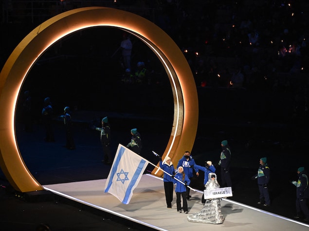 Le porte-drapeau israélien Jared Firestone défile avec d'autres athlètes lors de la cérémonie d'ouverture.