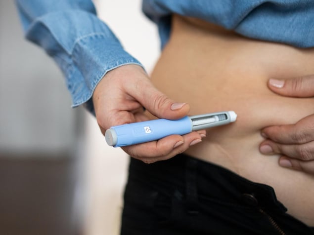 Une personne se fait une injection dans le ventre. 