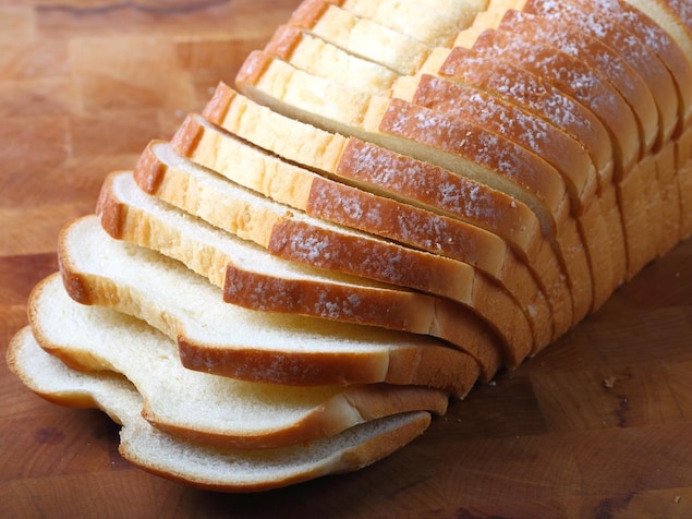 Du pain italien tranché est disposé sur une planche de bois.
