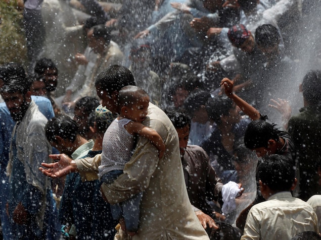 Des dizaines de personnes profitent de la fuite d'une conduite d'eau pour se rafraîchir. Des dizaines de personnes profitent de la fuite d'une conduite d'eau pour se rafraîchir.