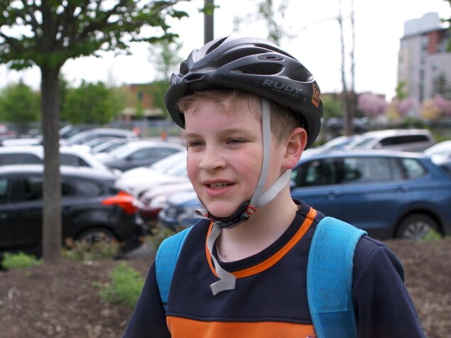 Le petit garçon avec son sac à dos sur les épaules et son casque de vélo sur la tête. Le petit garçon avec son sac à dos sur les épaules et son casque de vélo sur la tête.