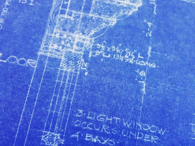 On voit en gros plan des plans architecturaux du parlement d'Ottawa datant de sa conception en 1916. On voit en gros plan des plans architecturaux du parlement d'Ottawa datant de sa conception en 1916.