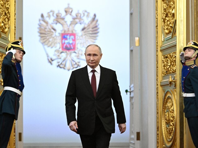 Entouré par deux gardes, Vladimir Poutine marche avant sa cérémonie d'investiture au Kremlin. 
