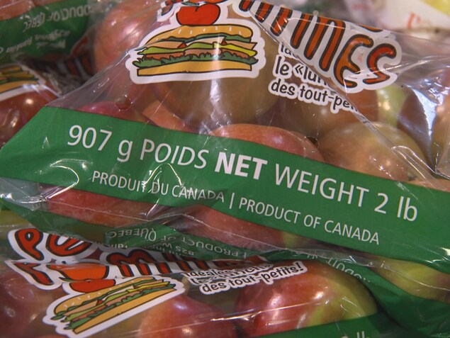 On voit en gros plan un sac de pommes. Sur le sac est écrit « Produit du Canada ». On voit en gros plan un sac de pommes. Sur le sac est écrit « Produit du Canada ».