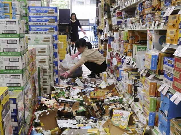 Les employées d'un commerce tentent de nettoyer les dégâts causés par le séisme. Des bouteilles et des canettes de bière jonchent le sol. Les employées d'un commerce tentent de nettoyer les dégâts causés par le séisme. Des bouteilles et des canettes de bière jonchent le sol.