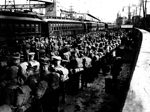 Des soldats attendent sur le quai d'une gare. Des soldats attendent sur le quai d'une gare.