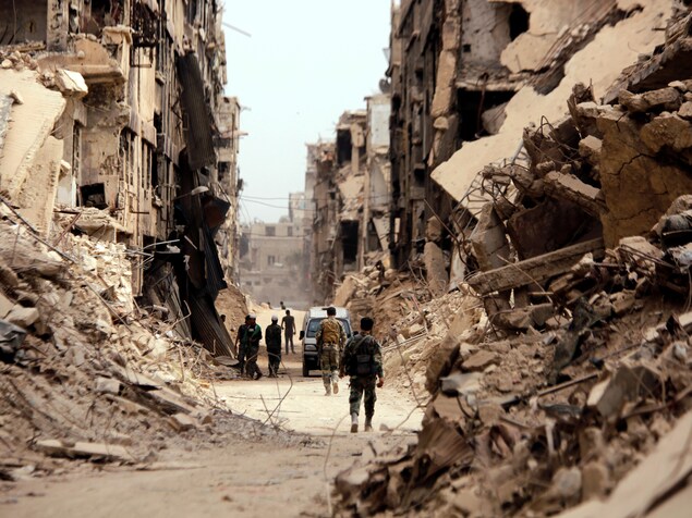 Des soldats marchent dans une rue de Damas. Des soldats marchent dans une rue de Damas.
