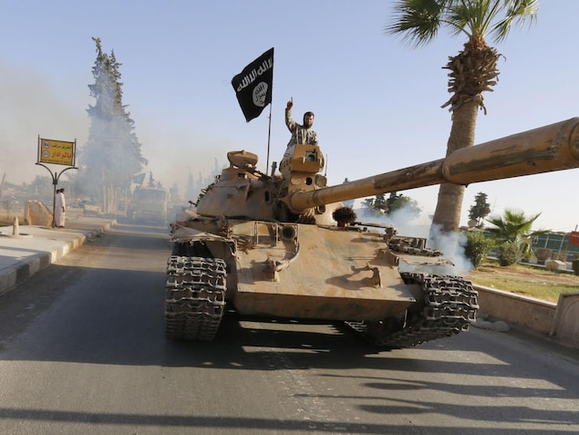 Un militant du groupe armé État islamique sur un tank dans la ville de Raqqa en Syrie en juin 2014