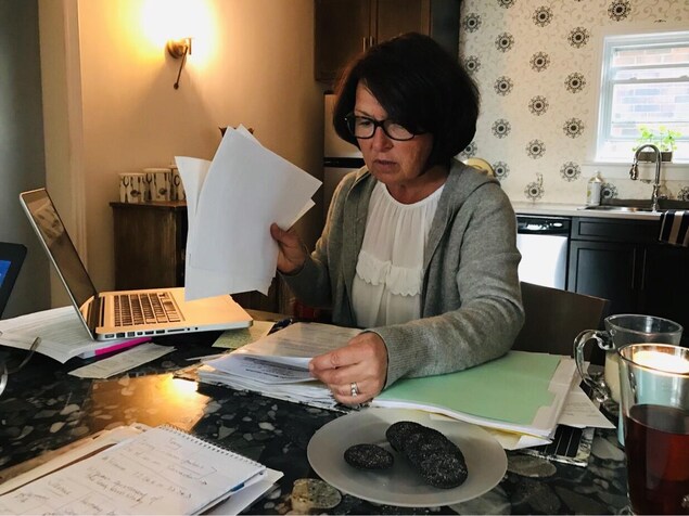 Terri talonne regarde des documents dans sa cuisine Terri talonne regarde des documents dans sa cuisine
