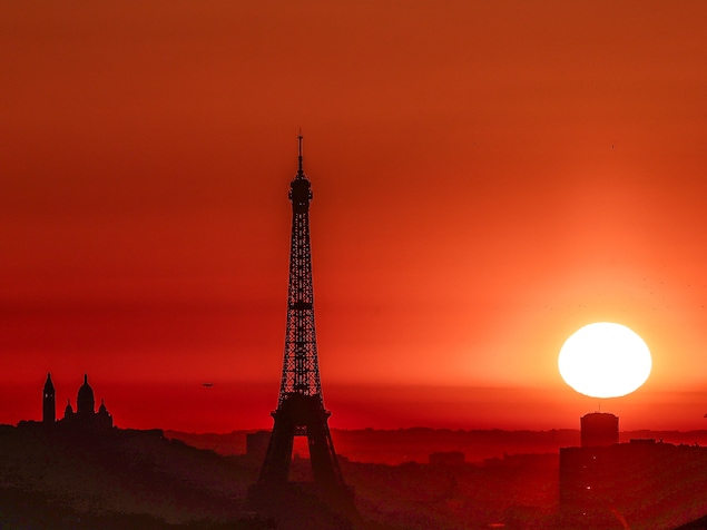 Le soleil se lève au-dessus de la tour Eiffel et de la basilique du Sacré-Cœur.