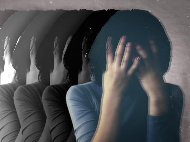 Une femme se tient la tête avec ses mains