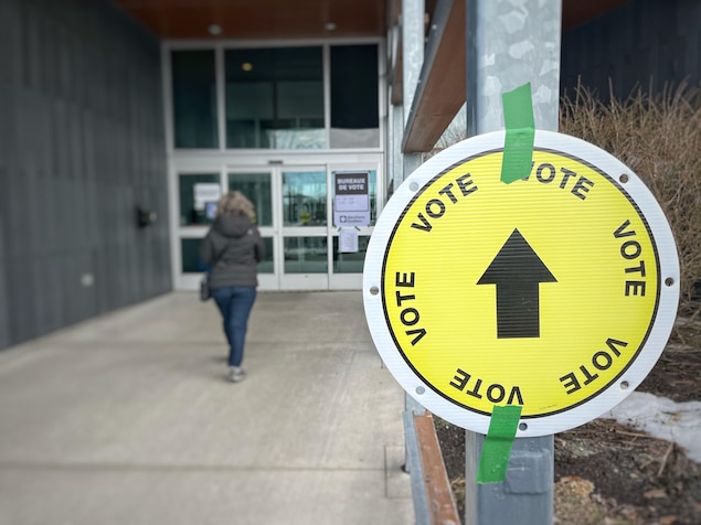 Une femme se dirigeant vers un bureau de vote.