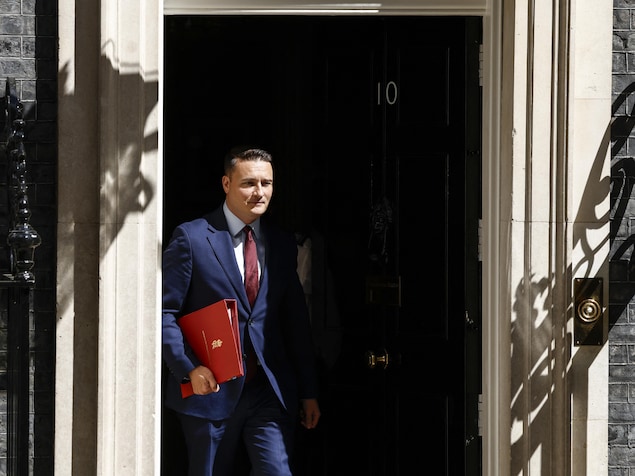 Wes Streeting marche vers l'extérieur d'un bâtiment.