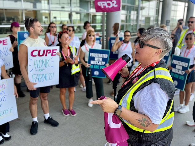La présidente du SCFP Manitoba, Gina McKay, avec un mégaphone.