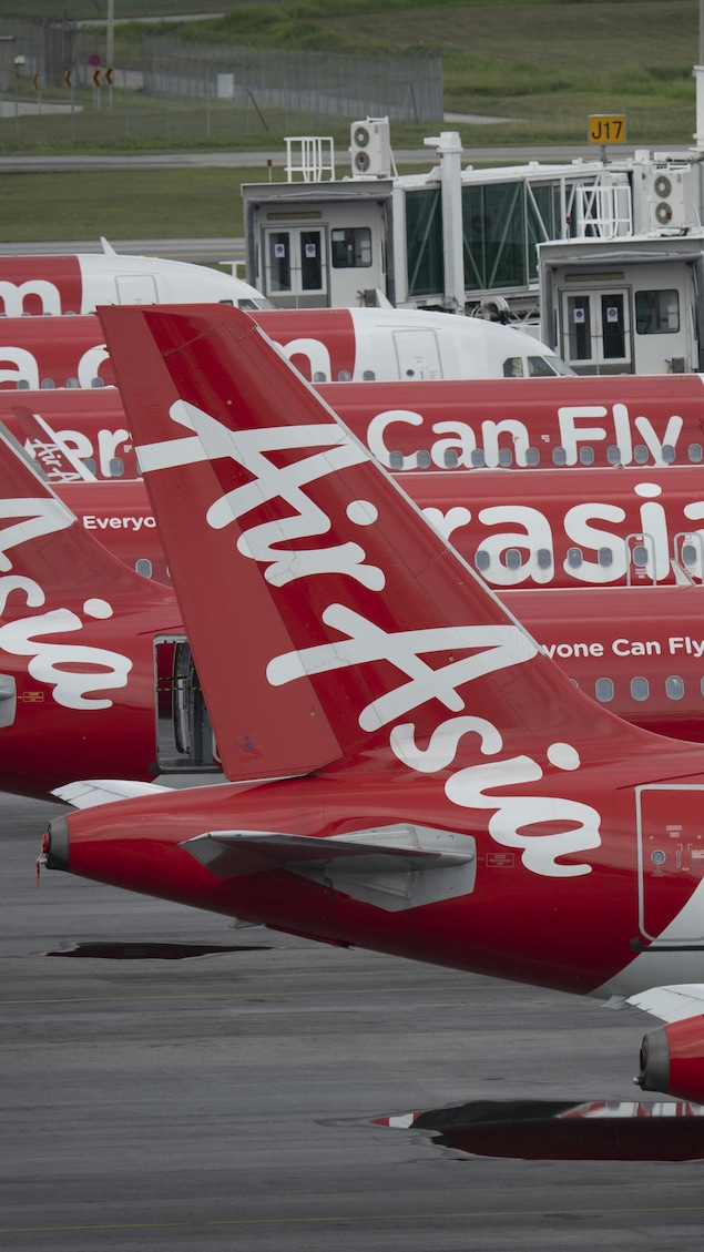 Des Airbus A320 d'Air Asia sont stationnés sur le tarmac d'un terminal en Malaisie. 