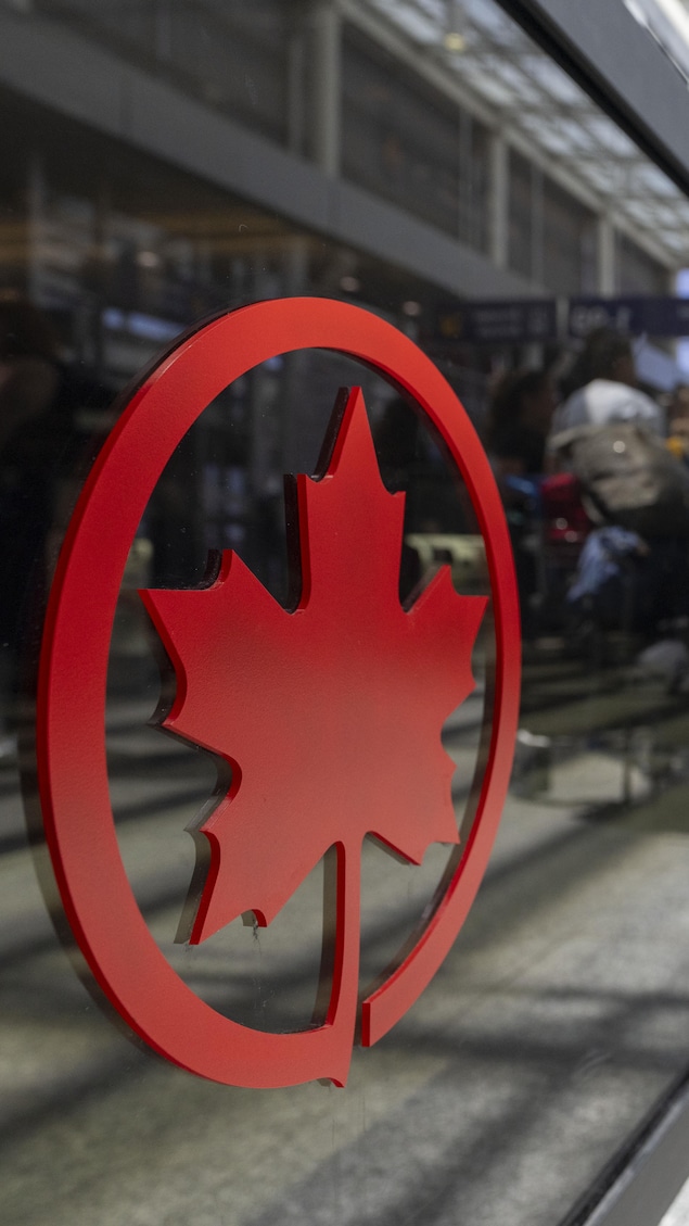 Des voyageurs au comptoir d'Air Canada à l'aéroport Montréal-Trudeau.