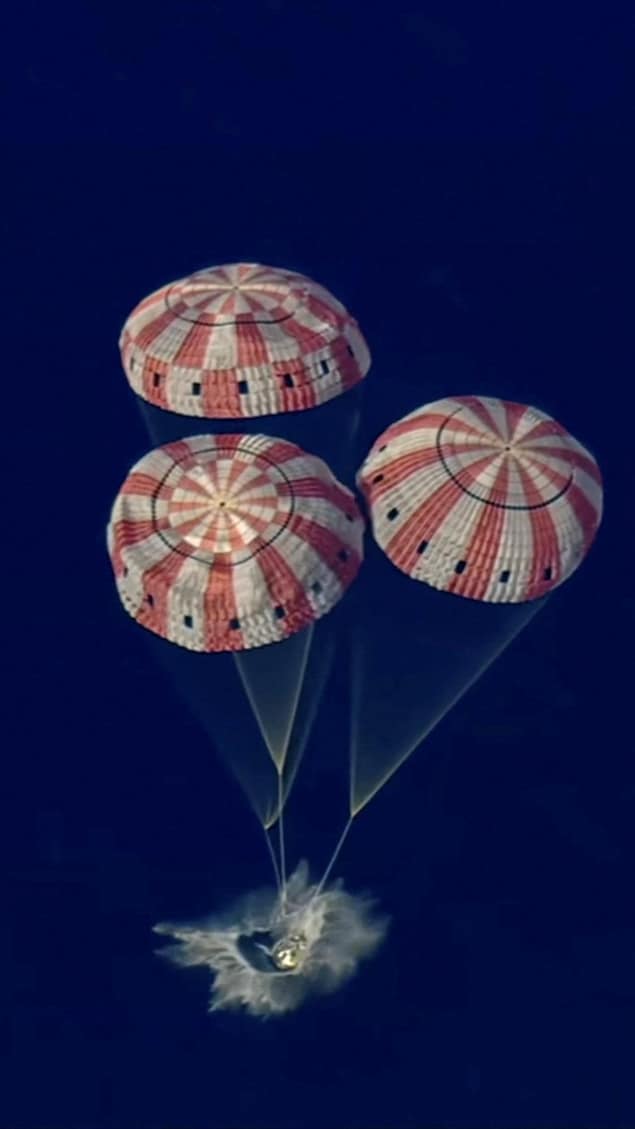 La capsule touche à l'eau de l'océen Pacifique, les parachutes encore déployés.
