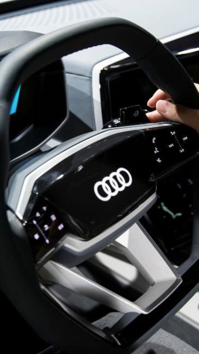 Le volant d'une voiture avec le logo d'Audi au milieu.