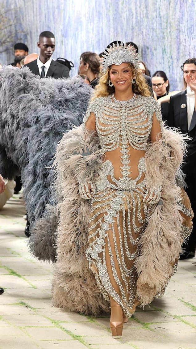 Beyoncé vêtue d'une robe sculpturale sur mesure, aux allures de squelette, avec une traîne à plumes crème et bleu poudre.